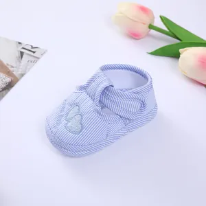 Detailed view of a soft-soled blue striped baby pre-walker shoe with heart embroidery.