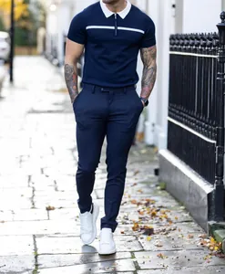 Detail of a slim fit navy men's polo with white collar and stripe in a street setting