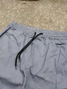 Détail d'un pantalon cargo gris pour homme avec taille élastique et cordon de serrage noir