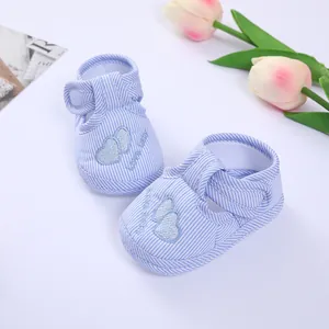 Close-up of soft blue striped infant shoes featuring delicate embroidered heart motifs