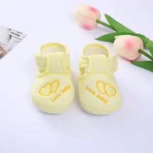 Detail view of soft yellow striped baby walking shoes with embroidered hearts.