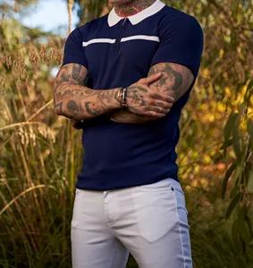 Close-up of navy slim fit polo shirt with white contrast collar and chest stripe