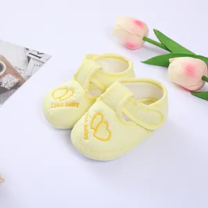 Detailed view of yellow striped baby pre-walker shoes featuring heart embroidery