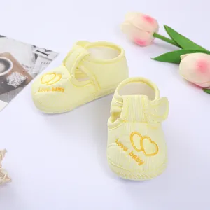 Detail view of yellow striped baby pre-walker shoes with embroidered heart pattern