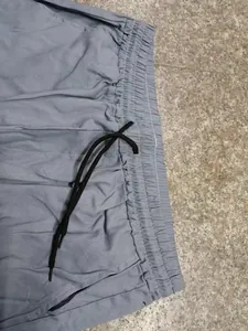 Détail de la taille élastique avec cordon de serrage d'un pantalon décontracté gris.