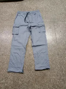 Détail du pantalon cargo gris pour homme avec taille à cordon et plusieurs poches pratiques