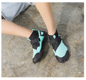 High-top aqua shoes with breathable mesh and anti-slip sole on rocky beach terrain