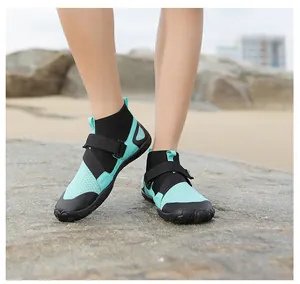 Outdoor detail shot of high-top aqua shoes worn on rocky beach terrain