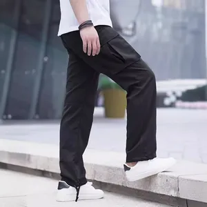Pantalon cargo noir décontracté pour homme avec plusieurs poches et ourlet à cordon réglable.