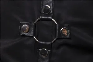 Dettaglio dell'anello di metallo e dei rivetti su una camicia nera stile gotico.