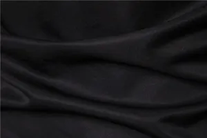 Vista macro della trama liscia e del drappeggio del tessuto nero della camicia Gothic