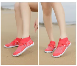Detail view of high-top red water shoes with breathable mesh and anti-slip sole on beach sand