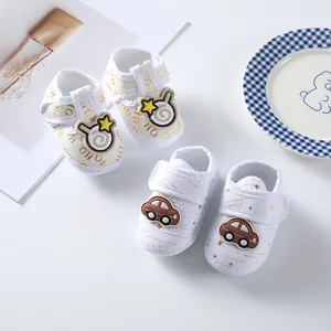 Close-up of soft-sole baby shoes with car and star patterns for infants