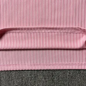 Detail shot of the pink ribbed fabric and precise hem stitching on men's knit vest