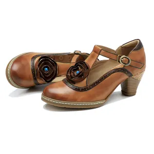 Close-up of vintage brown leather Mary Jane heels with hand-rubbed finish and floral detail.
