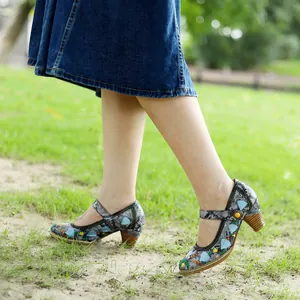 Detailansicht von Mary Jane Pumps mit Vintage-Blumenstickerei und Blockabsatz im Park