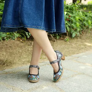 Detailansicht von Vintage bestickten Mary Janes mit Blockabsatz und einem Jeansrock.