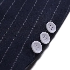 Close-up detail of navy blue pinstripe blazer cuff showing three white decorative buttons