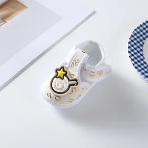 Macro view of white T-strap baby shoe featuring gold pattern and a cute cartoon star patch