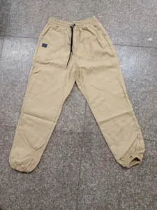 Detalle de pantalones jogger de algodón beige con cintura elástica y cordón negro