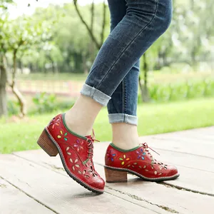 Side view of retro red leather shoes featuring colorful floral cutouts and wooden block heels