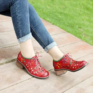 Detailed view of red vintage handmade leather shoes with floral hollow cutouts