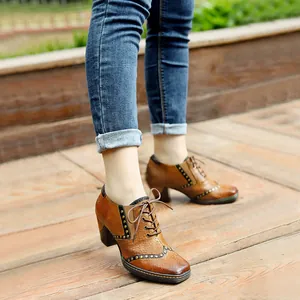 Vista detallada de zapatos vintage de cuero marrón con cordones, tacón ancho y tachuelas