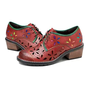 Detail of vintage handmade leather shoes featuring colorful floral cutouts and lace-up design