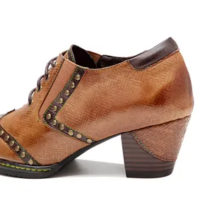 Detalle de zapato de cuero vintage con tacón de bloque, remaches y patrones grabados
