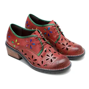 Close-up detail view of vintage handmade leather shoes with floral hollow-out design