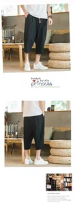 Front and back views of men's black linen cropped harem pants with tassel drawstring.