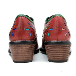 Detailed macro view of retro red leather shoe heels with colorful floral cutouts and wood texture