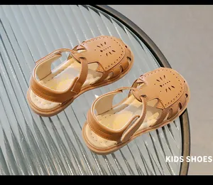 Vue détaillée de sandales marron ajourées pour enfants avec motifs floraux découpés