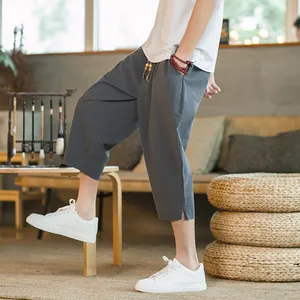Detail view of men's grey linen harem pants in a relaxed Chinese style indoor setting