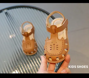 Gros plan de sandales marron ajourées pour tout-petits avec un joli design de chat