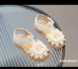 Sandales blanches mignonnes pour bébé avec détails de motifs de fleurs évidés