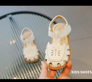 Vue détaillée de sandales blanches fermées pour bébés avec motifs de découpe papillon