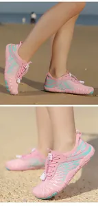Vue détaillée de chaussures d'eau roses respirantes à séchage rapide sur une plage de sable.