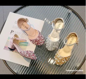 Close-up of pink, silver, and gold girls' princess shoes with pearl and rhinestone decor.
