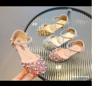 Close-up detail of children's pink sparkle princess shoes with pearl and rhinestone embellishments