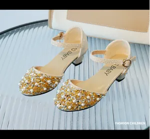 Close-up detail of elegant gold sequined girls princess shoes decorated with pearls and crystals