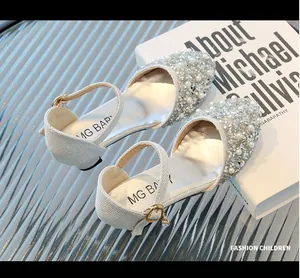 Close-up of girl's princess shoes with shiny rhinestones and elegant white pearls.