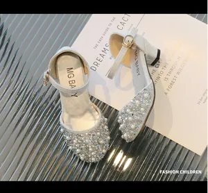 Close-up of girls' silver high heels with sparkling pearls and rhinestones detail