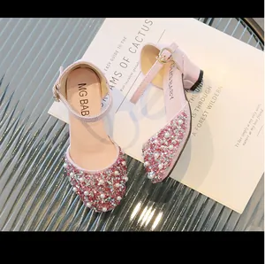 Close-up of pink girls princess shoes decorated with pearls and sparkly rhinestones