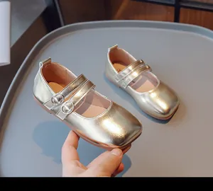 Detailansicht glänzender goldener Mädchen-Ballerinas mit quadratischer Spitze und Riemchen