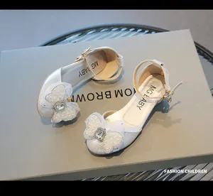 Close-up of sparkling silver girl's dress shoe with large pearl butterfly bow