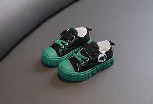 Détail des chaussures en toile pour enfants noir et vert avec brides velcro.