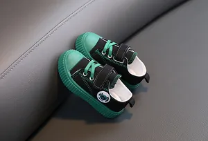 Gros plan de chaussures en toile pour enfants noir et vert avec velcro et semelle en caoutchouc