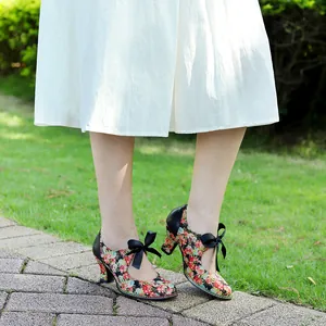 Close-up of retro floral high heels featuring elegant black bow ties and sturdy spool heels
