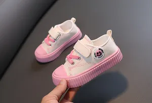 Vue détaillée de baskets en toile rose et blanc pour enfants avec velcro et lacets